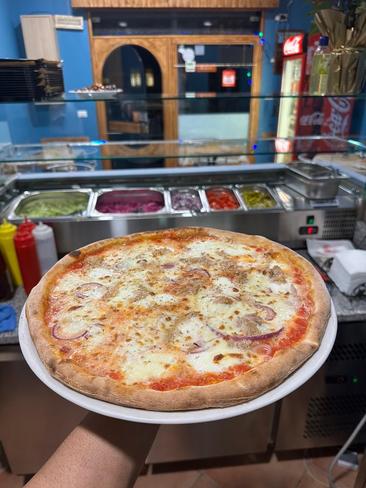 Una pizza appena sfornata al bancone del Drago Verde